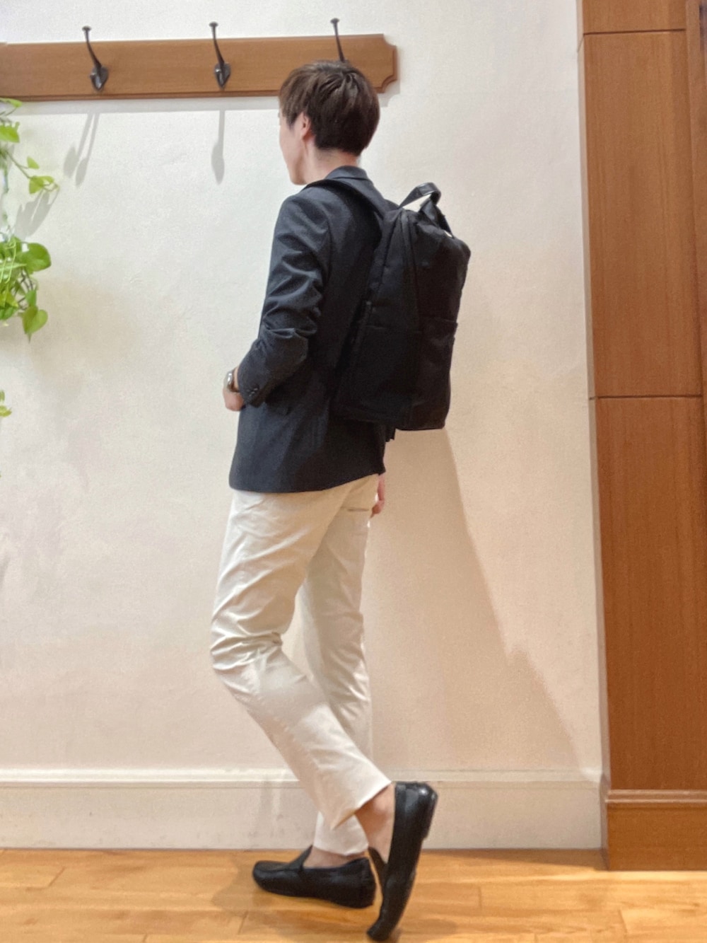 ホワイト系のチノパンツ、ブラック系のバックパック/リュック、ブルー系のテーラードジャケットを着用したメンズの秋コーディネートの4枚目の写真