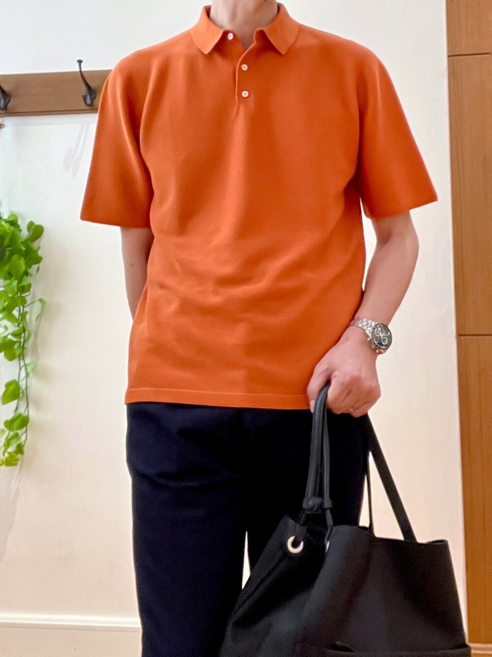 オレンジ系のポロシャツ、ブラック系のトートバッグ、ブルー系のその他パンツを着用したメンズの春コーディネートの8枚目の写真