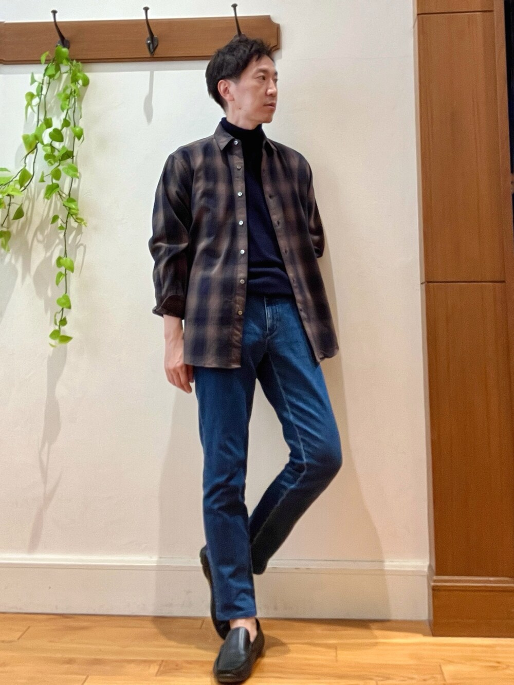 グリーン系のシャツ/ブラウス、ブルー系のニット/セーター、ブルー系のデニムパンツを着用したメンズの冬コーディネートの7枚目の写真