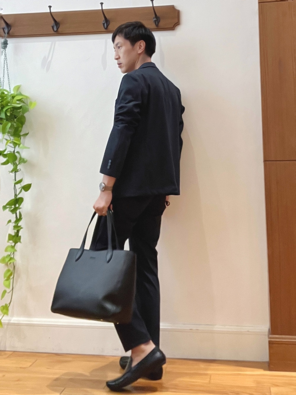 ブルー系のその他パンツ、ブラック系のトートバッグ、ブラック系のTシャツ/カットソーを着用したメンズの秋コーディネートの3枚目の写真