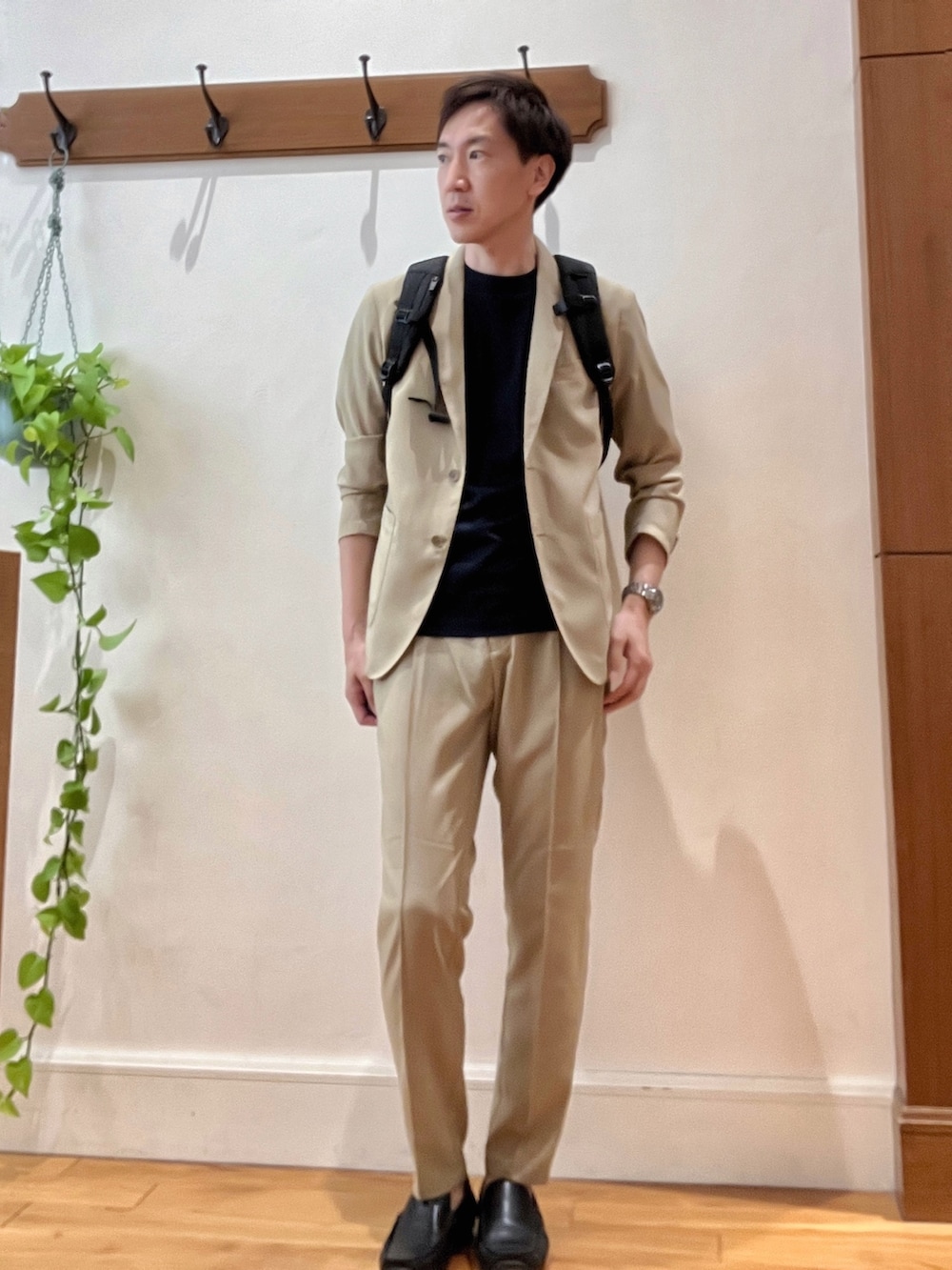 ベージュ系のテーラードジャケット、ブルー系のTシャツ/カットソー、ブラック系のバックパック/リュックを着用したメンズの春コーディネートの2枚目の写真