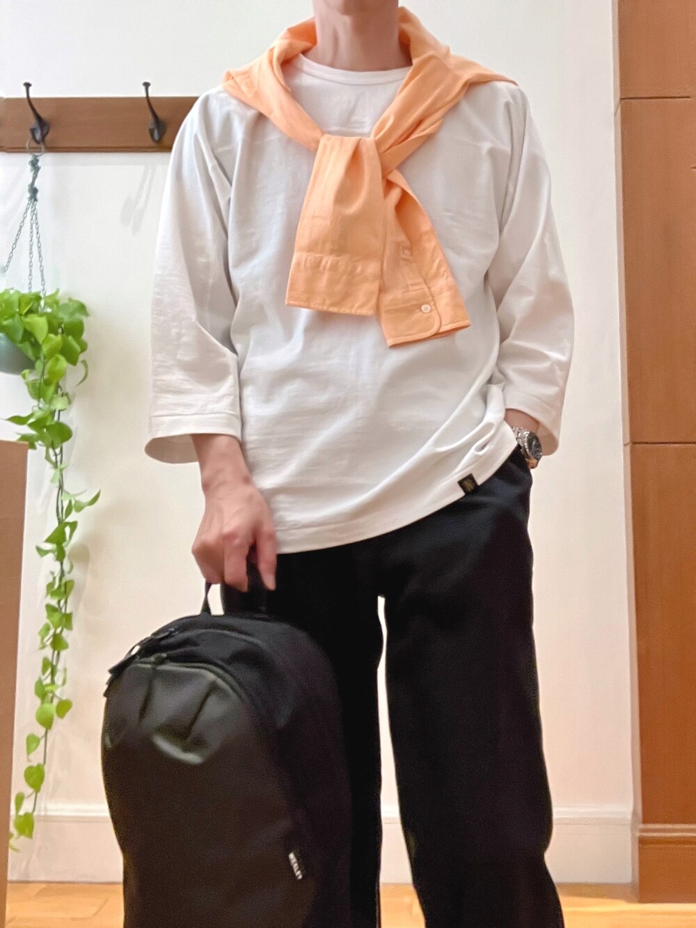 オレンジ系のシャツ/ブラウス、ブラック系のその他パンツ、グレー系のバックパック/リュックを着用したメンズの春コーディネートの8枚目の写真