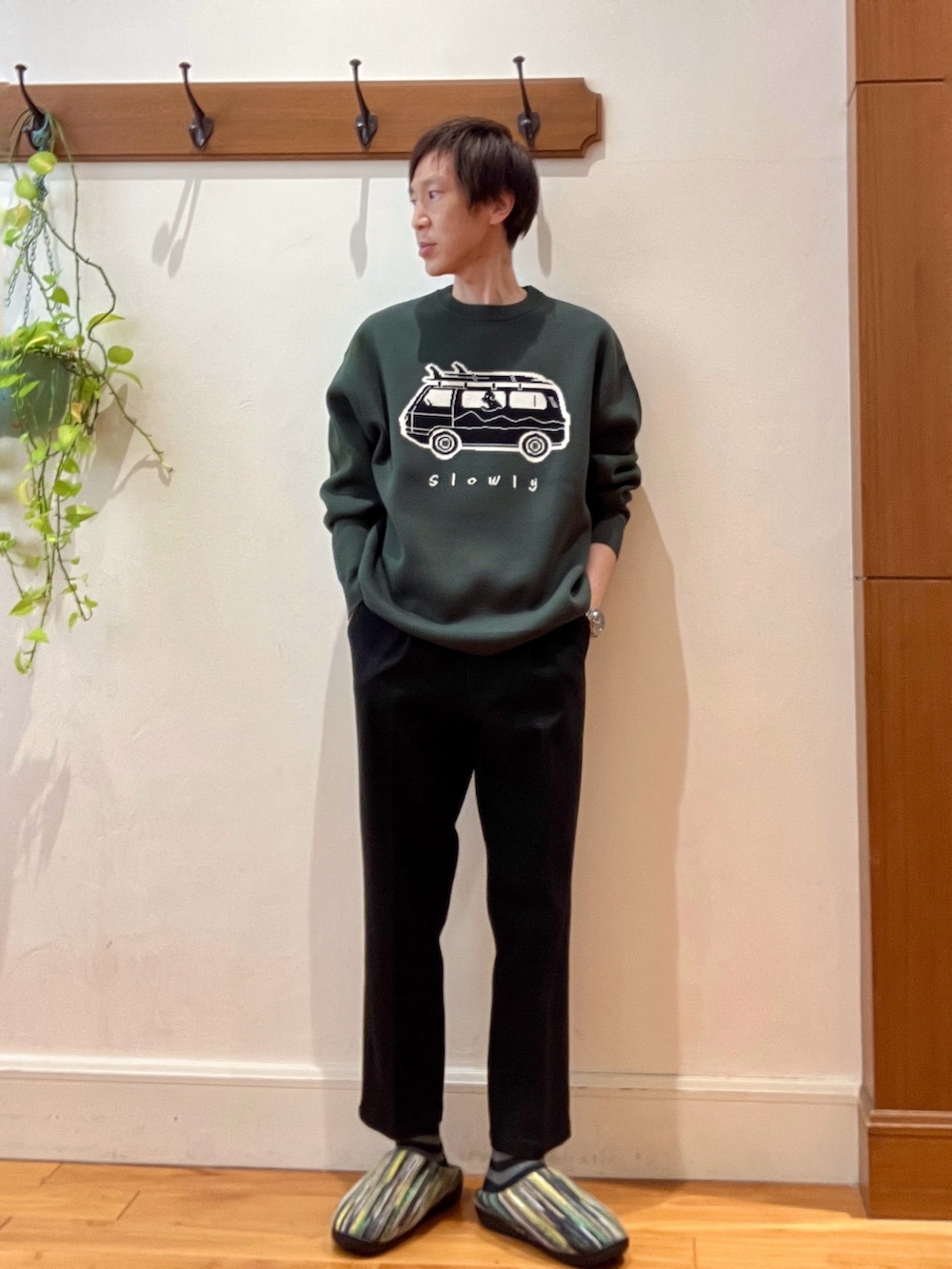 グリーン系のニット/セーター、ブラック系のショルダーバッグ、グリーン系のサンダルを着用したメンズの冬コーディネートの9枚目の写真