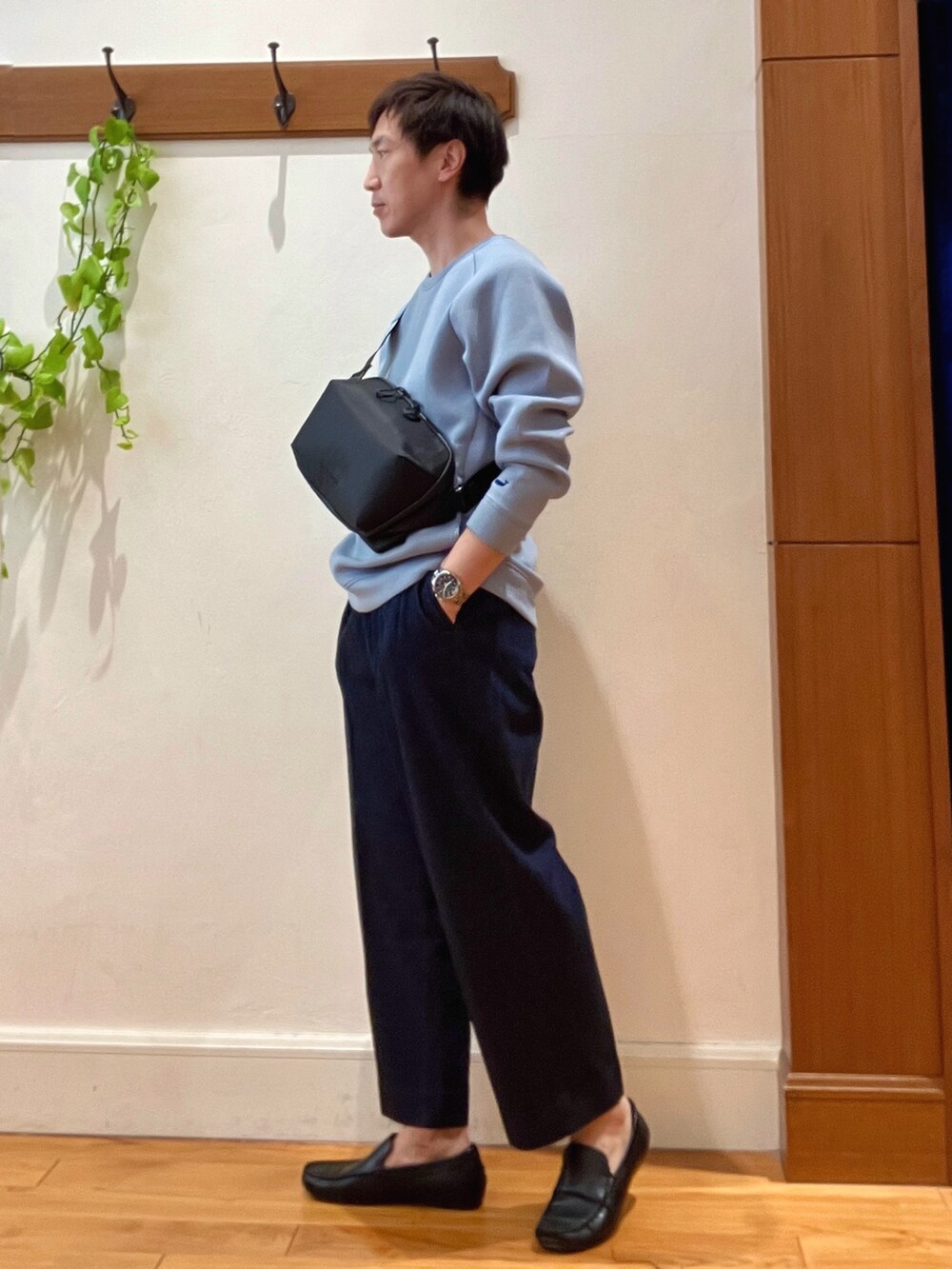 ブルー系のデニムパンツ、ブルー系のスウェット、ブラック系のショルダーバッグを着用したメンズの冬コーディネートの3枚目の写真