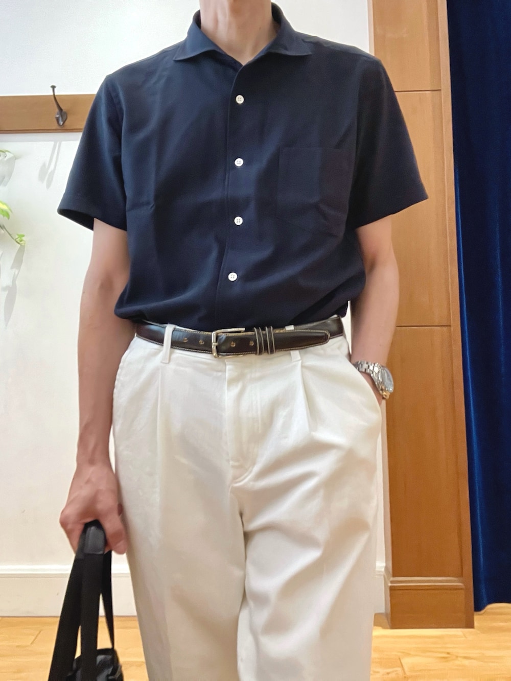 ホワイト系のデニムパンツ、ブルー系のビジネスシャツ、ブラック系のトートバッグを着用したメンズの夏コーディネートの7枚目の写真