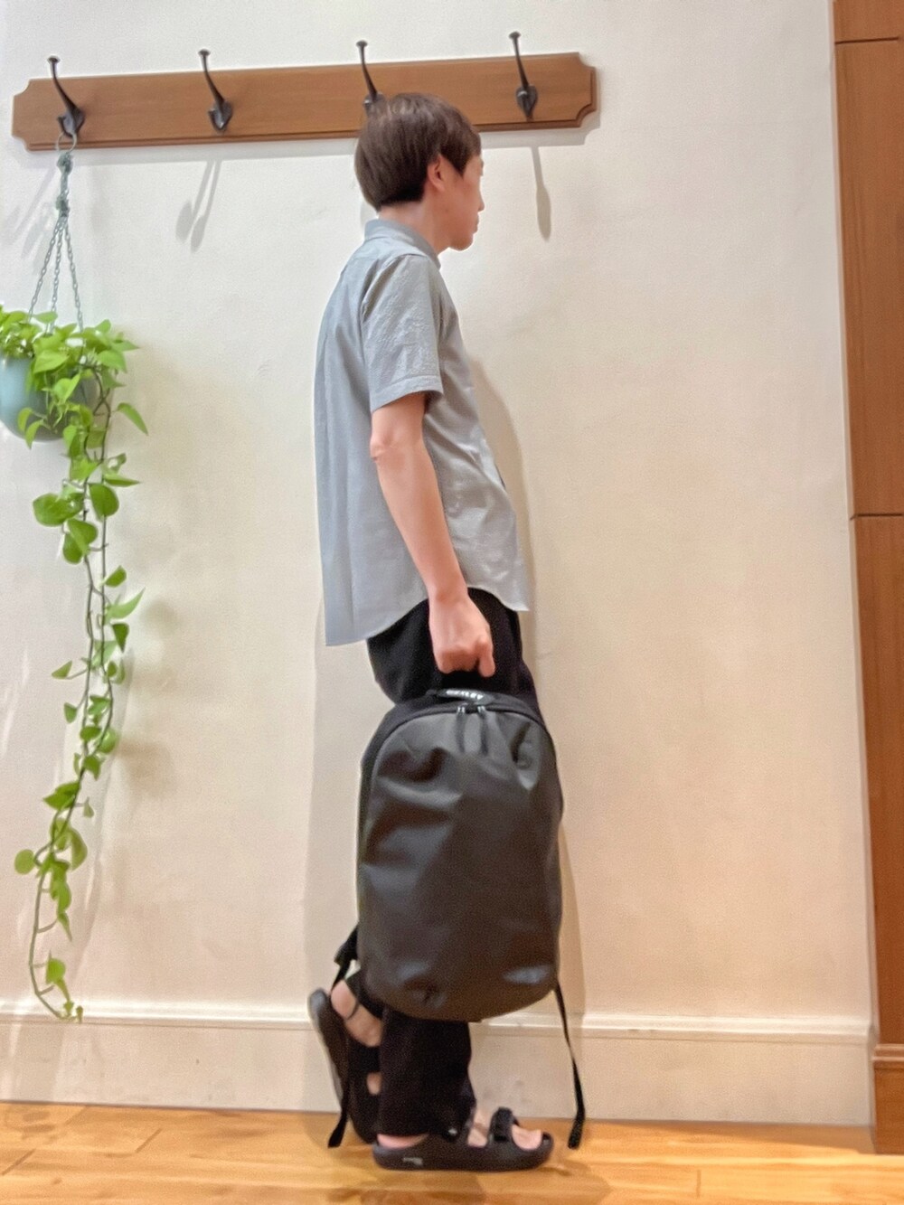 ブラック系のサンダル、グレー系のバックパック/リュック、ブラック系のその他パンツを着用したメンズの春コーディネートの6枚目の写真