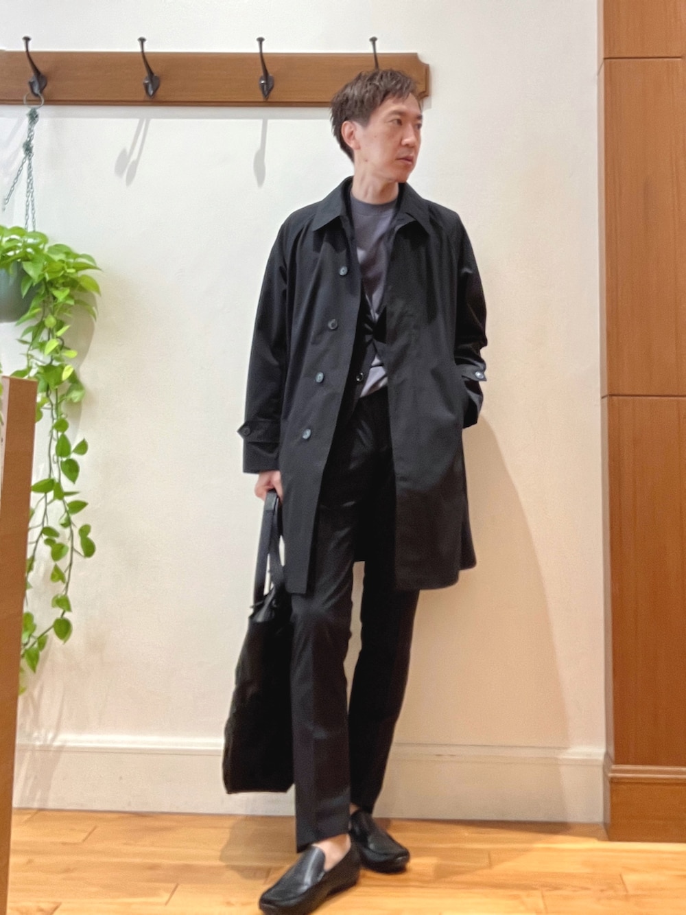 ブラック系のステンカラーコート、グレー系のTシャツ/カットソー、ブラック系のその他パンツを着用したメンズの夏コーディネートの2枚目の写真