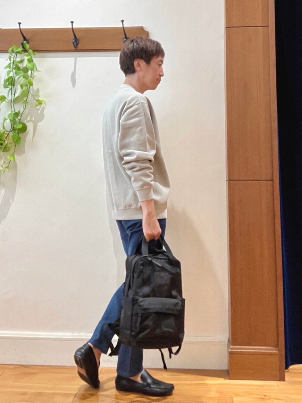 ベージュ系のスウェット、ブルー系のデニムパンツ、ブラック系のバックパック/リュックを着用したメンズの秋コーディネートの6枚目の写真