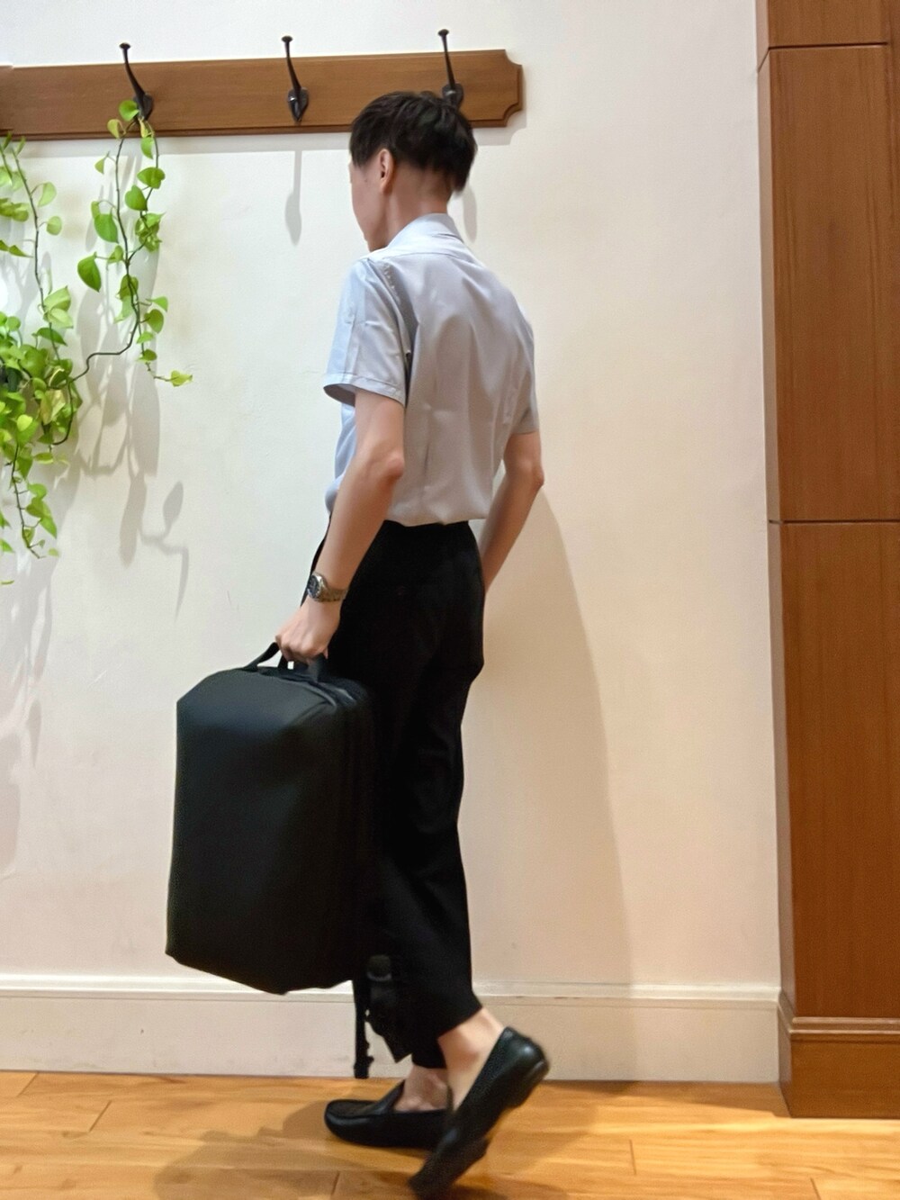 ブラック系のスラックス、ブルー系のビジネスシャツ、ブラック系のバックパック/リュックを着用したメンズの夏コーディネートの3枚目の写真