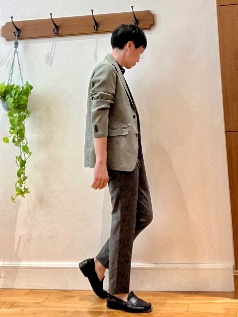 グリーン系のテーラードジャケット、ブラック系のポロシャツ、グレー系のその他パンツを着用したメンズの春コーディネートの6枚目の写真