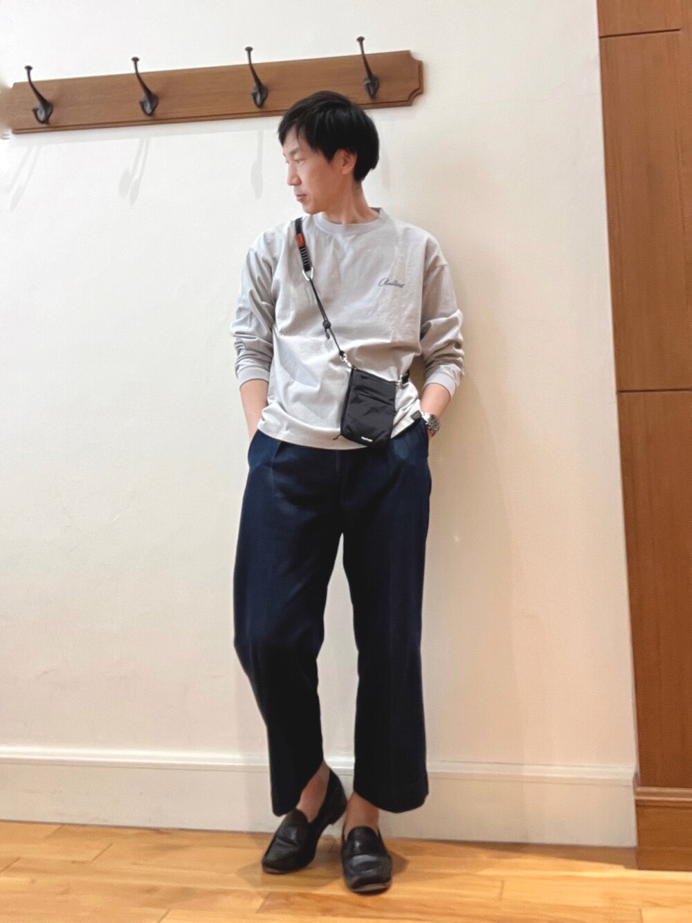 グレー系のTシャツ/カットソー、ブラック系のショルダーバッグ、ブラック系のスマホグッズを着用したメンズの春コーディネートの2枚目の写真