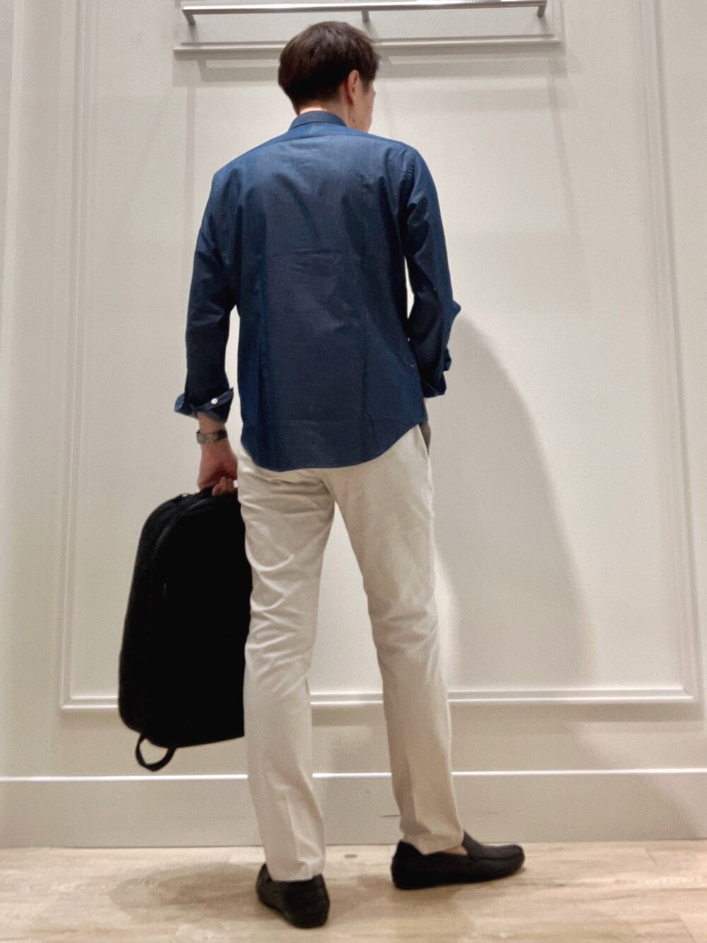 ブラック系のバックパック/リュック、グレー系のチノパンツ、ブルー系のシャツ/ブラウスを着用したメンズの冬コーディネートの4枚目の写真