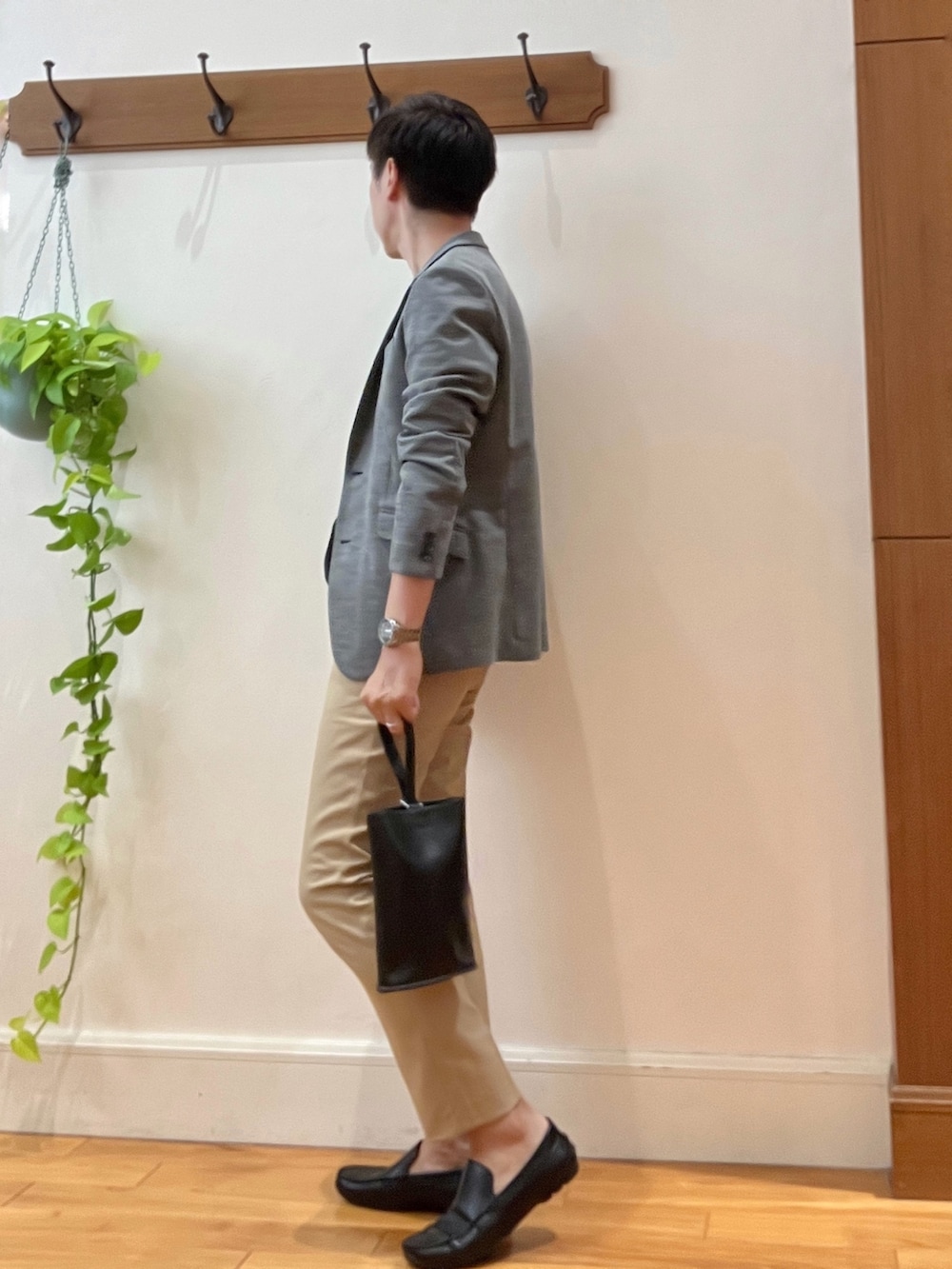 グレー系のテーラードジャケット、ブラック系のTシャツ/カットソー、ブラック系のハンドバッグを着用したメンズの秋コーディネートの4枚目の写真