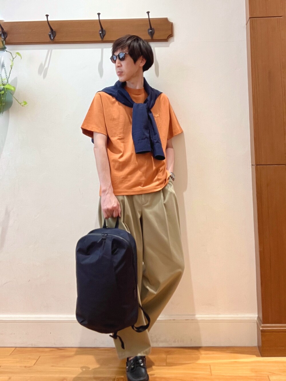 ブラック系のバックパック/リュック、ブルー系のシャツ/ブラウス、オレンジ系のTシャツ/カットソーを着用したメンズの春コーディネートの8枚目の写真