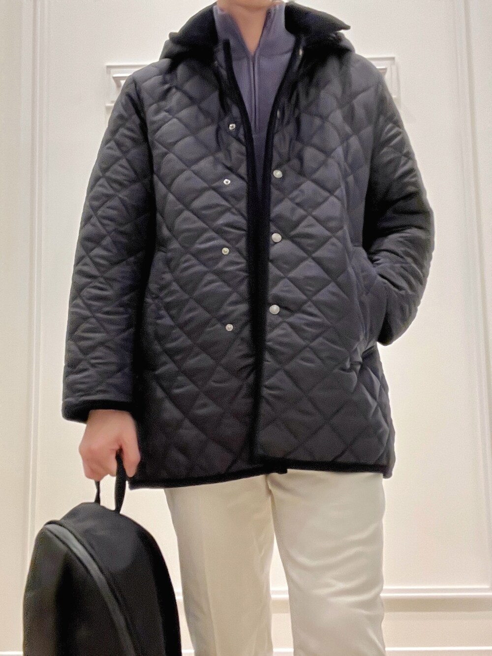 ブルー系のステンカラーコート、ブルー系のニット/セーター、ホワイト系のチノパンツを着用したメンズの冬コーディネートの9枚目の写真