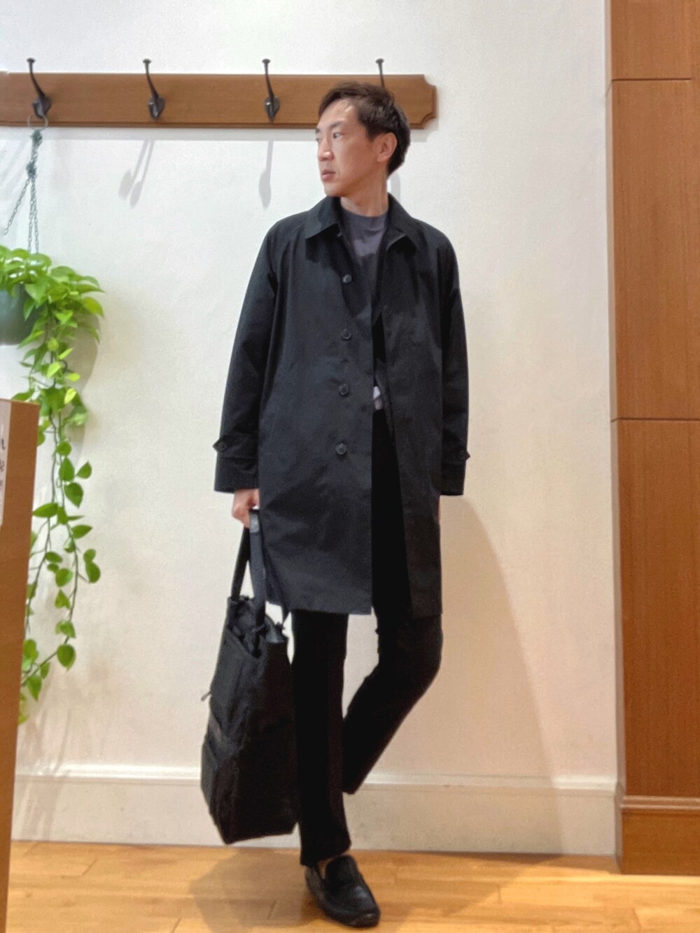 ブラック系のステンカラーコート、グレー系のTシャツ/カットソー、ブラック系のその他パンツを着用したメンズの夏コーディネートの6枚目の写真