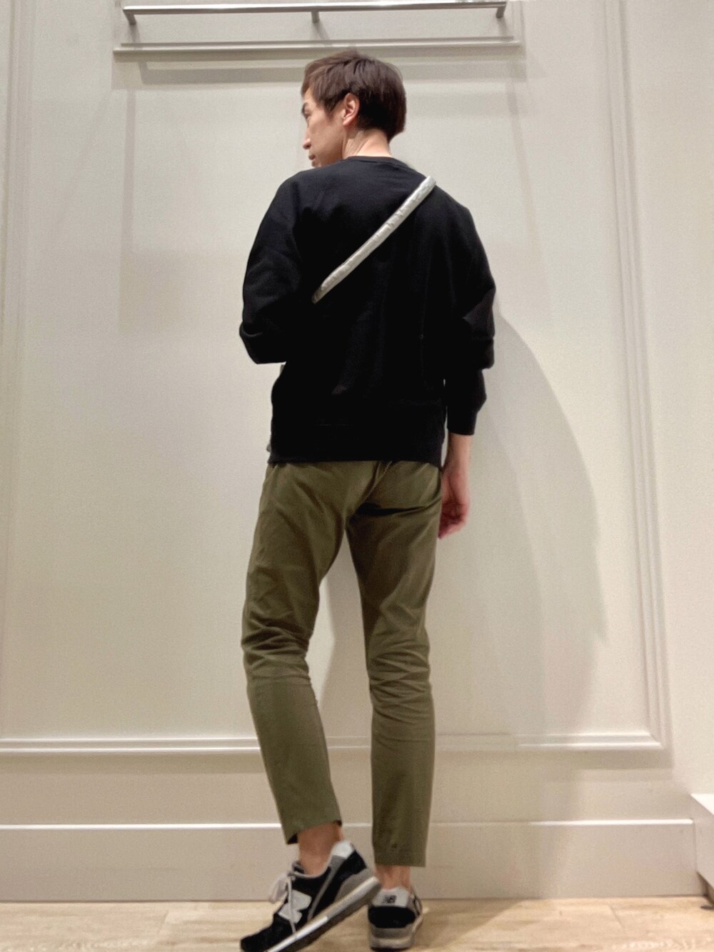 ブラック系のスウェット、グリーン系のショルダーバッグを着用したメンズの冬コーディネートの4枚目の写真