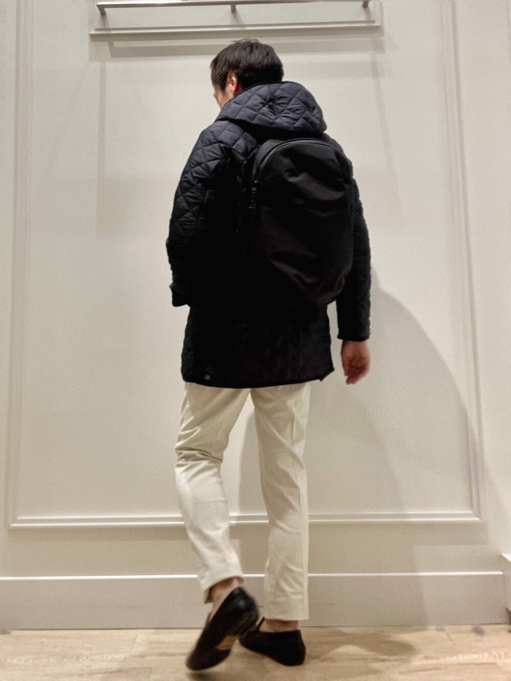 ブルー系のステンカラーコート、ブルー系のニット/セーター、ホワイト系のチノパンツを着用したメンズの冬コーディネートの6枚目の写真