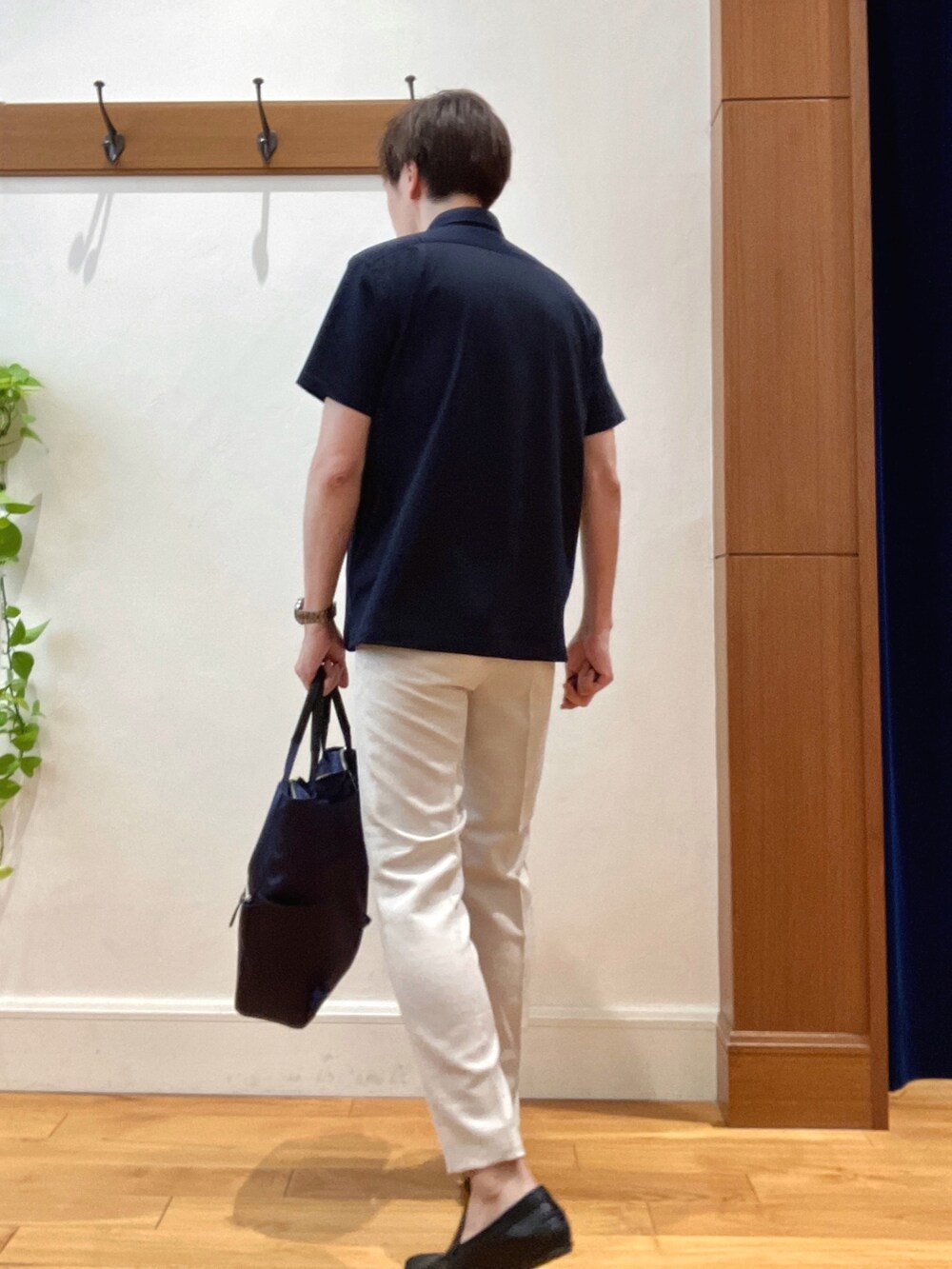 ブルー系のトートバッグ、ブルー系のポロシャツ、ホワイト系のその他パンツを着用したメンズの夏コーディネートの4枚目の写真