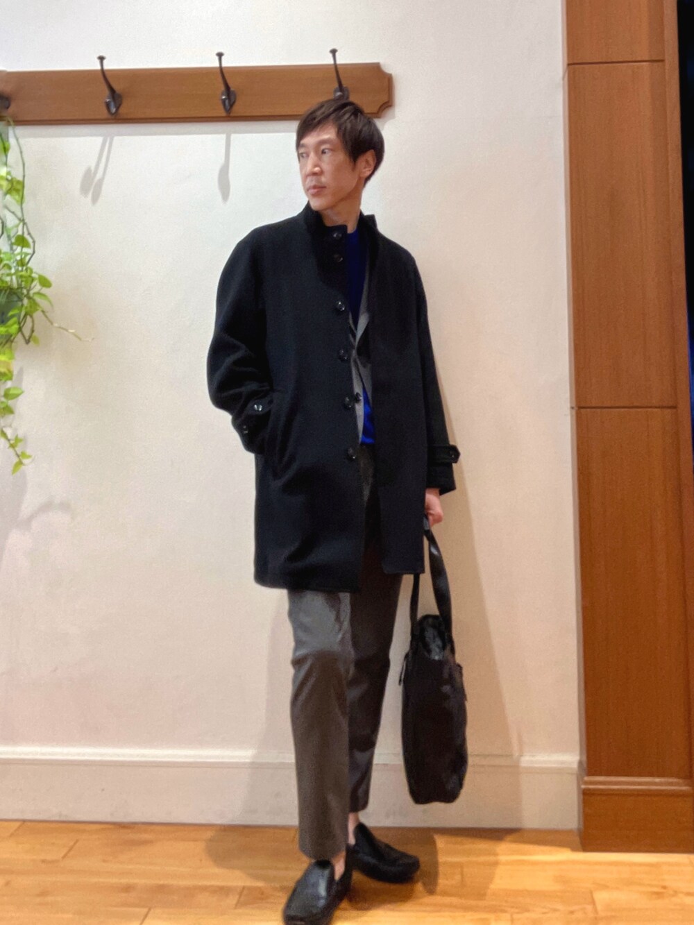 ブラック系のその他アウター、ブルー系のニット/セーター、グレー系のテーラードジャケットを着用したメンズの秋コーディネートの6枚目の写真