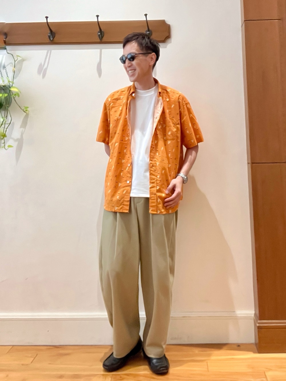 オレンジ系のシャツ/ブラウス、ホワイト系のTシャツ/カットソー、ブラウン系のサングラスを着用したメンズの夏コーディネートの2枚目の写真