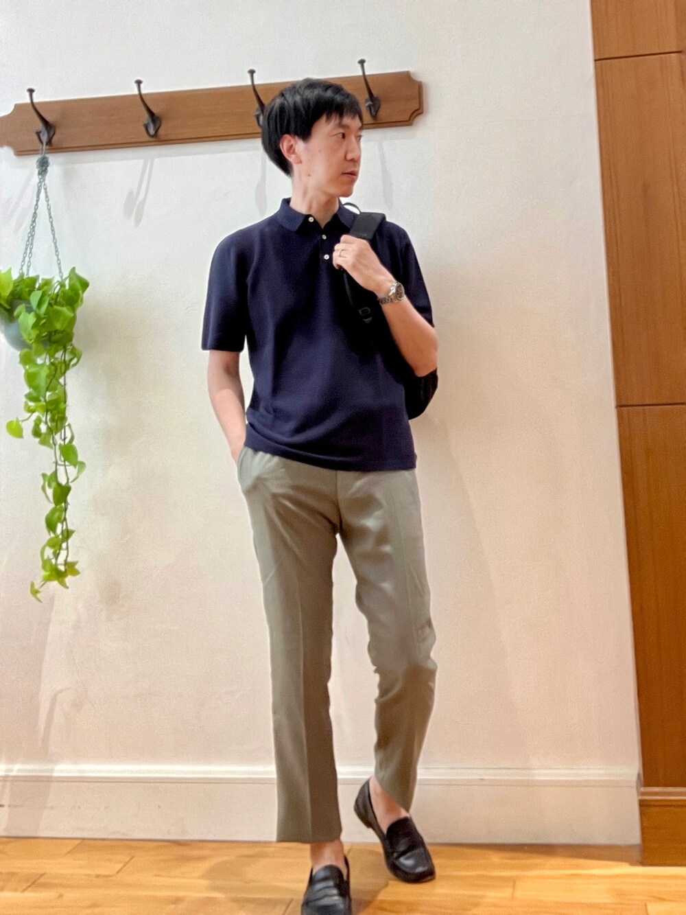 ブルー系のポロシャツ、ブラック系のバックパック/リュック、ブラック系のその他パンツを着用したメンズの春コーディネートの2枚目の写真