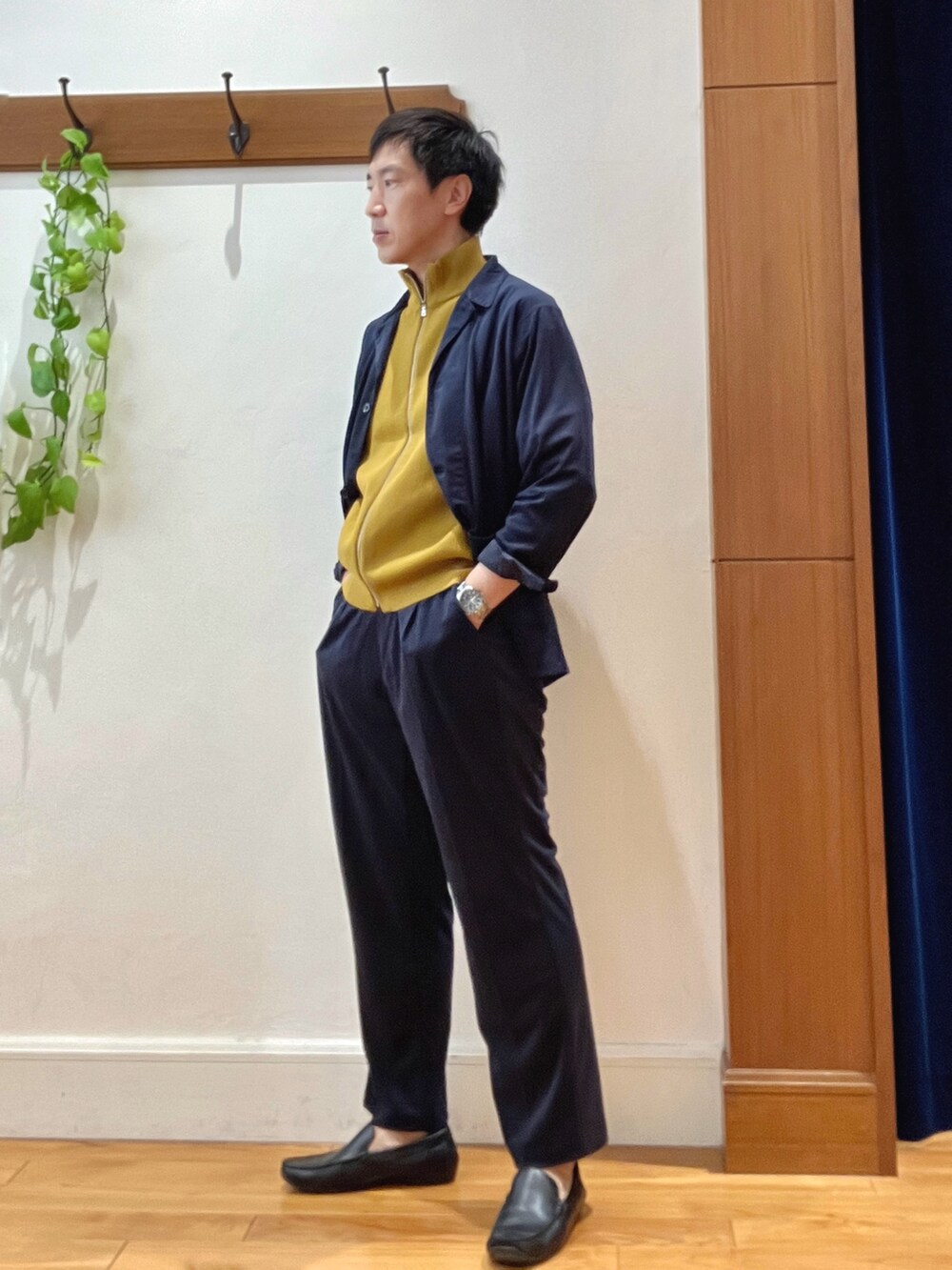 ブルー系のシャツ/ブラウス、イエロー系のニット/セーター、グレー系のバックパック/リュックを着用したメンズの秋コーディネートの3枚目の写真