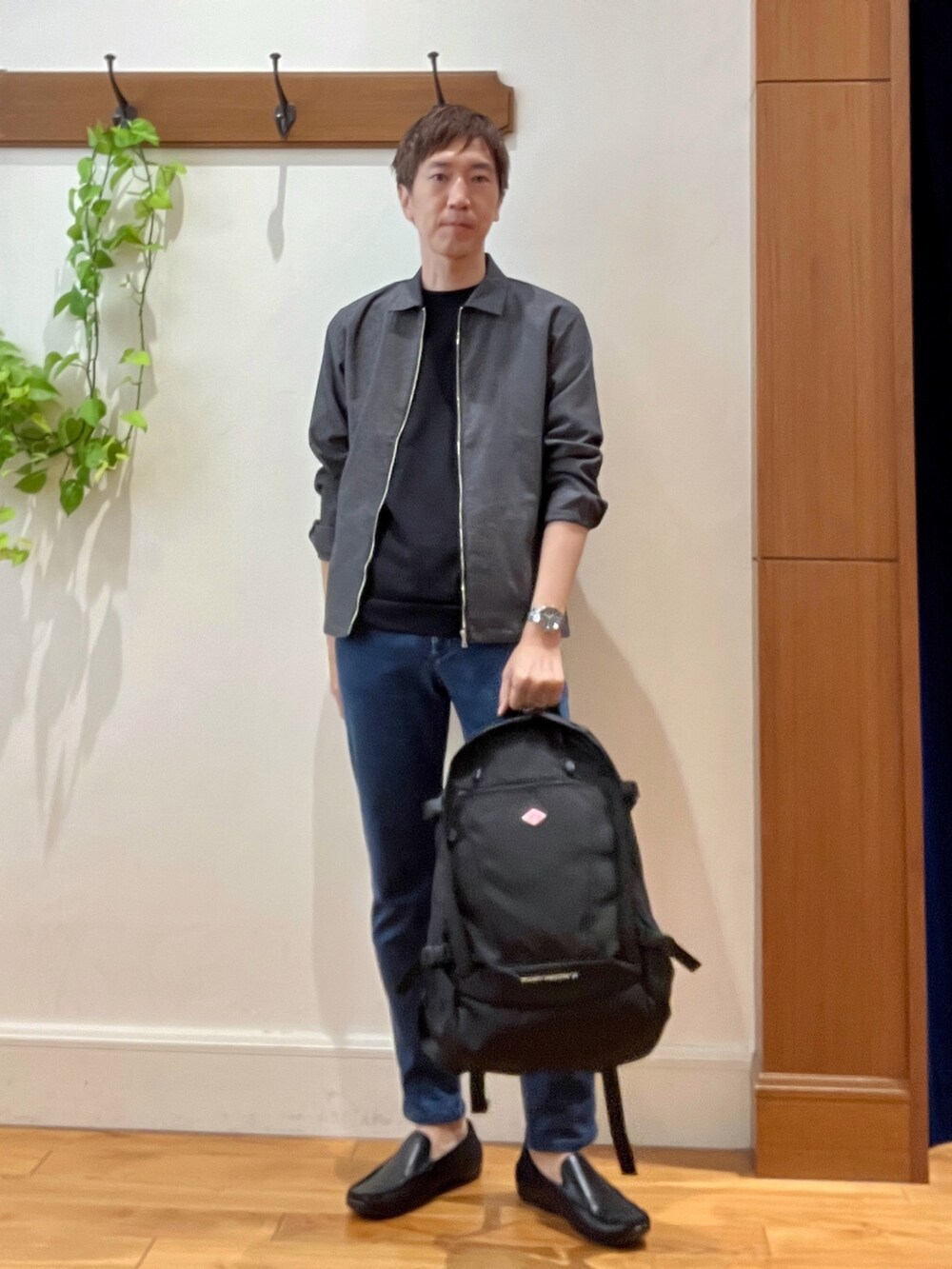 ブラック系のバックパック/リュック、ブルー系のデニムパンツ、ブラック系のTシャツ/カットソーを着用したメンズの夏コーディネートの2枚目の写真
