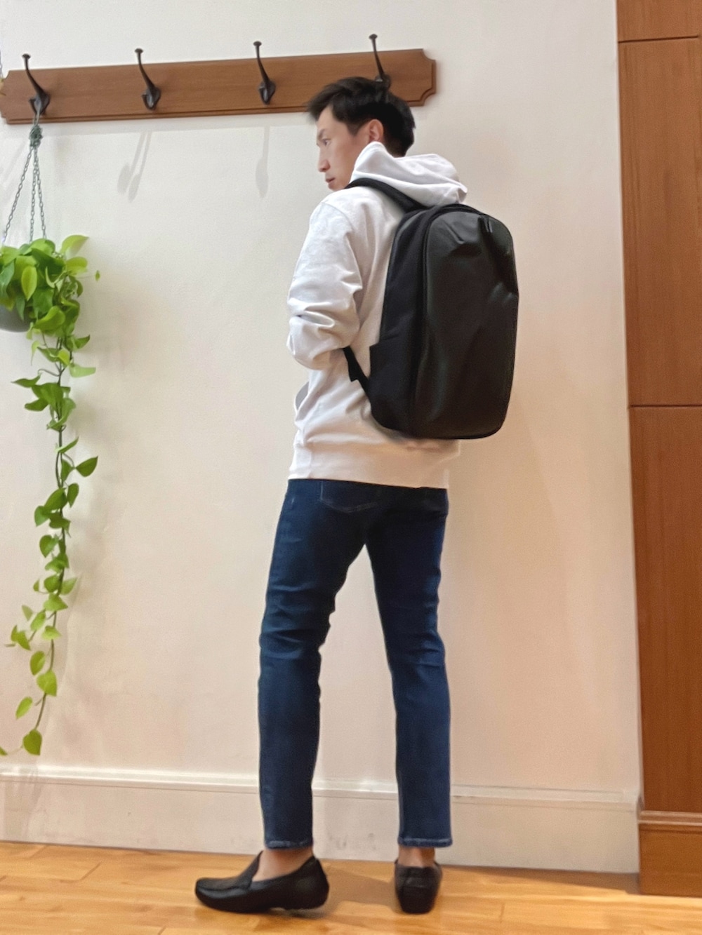 グレー系のパーカー、ブルー系のデニムパンツ、ブラック系のバックパック/リュックを着用したメンズの秋コーディネートの3枚目の写真