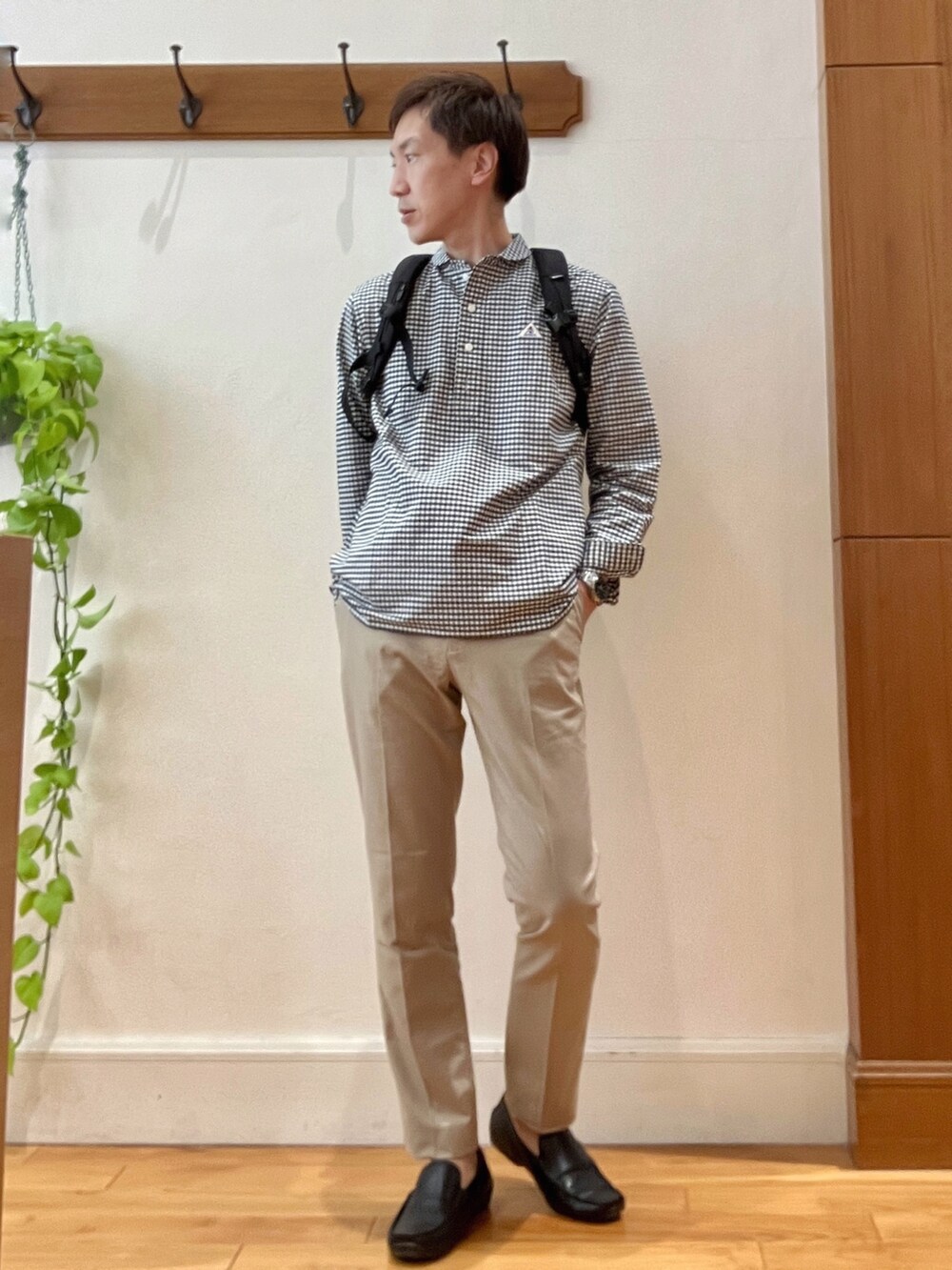 ブラック系のシャツ/ブラウス、グレー系のバックパック/リュック、ベージュ系のチノパンツを着用したメンズの春コーディネートの8枚目の写真