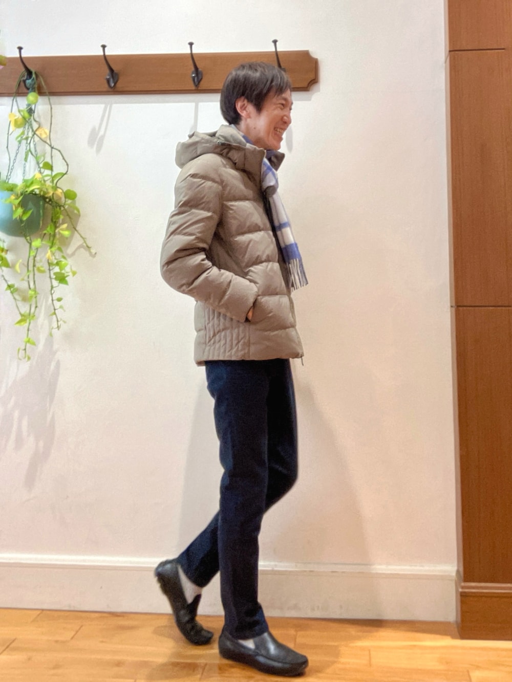 グリーン系のダウンジャケット/コート、ブルー系のニット/セーター、ブルー系のデニムパンツを着用したメンズの冬コーディネートの6枚目の写真