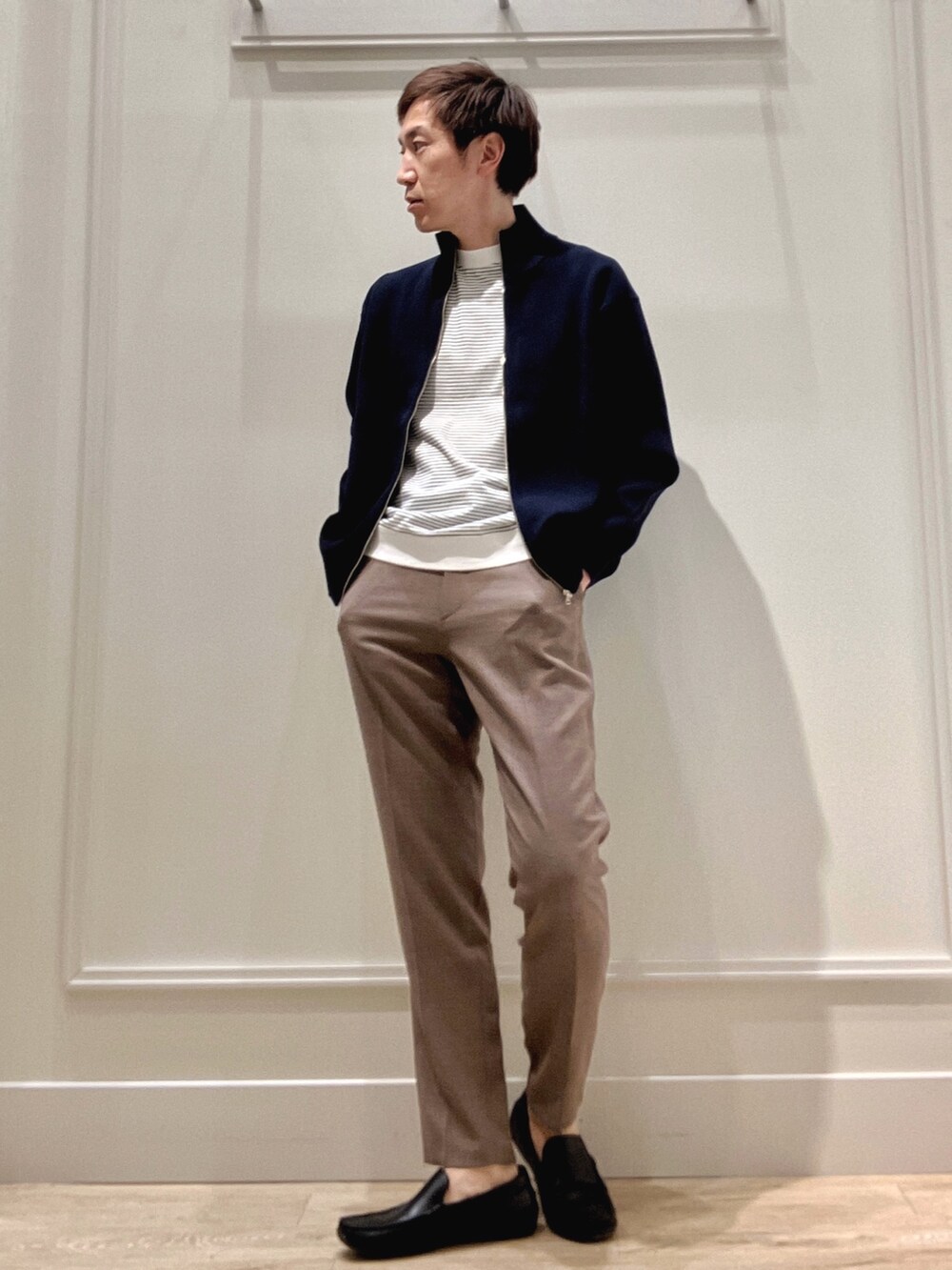 ブルー系のニット/セーター、ホワイト系のTシャツ/カットソー、ベージュ系のその他パンツを着用したメンズの冬コーディネートの7枚目の写真