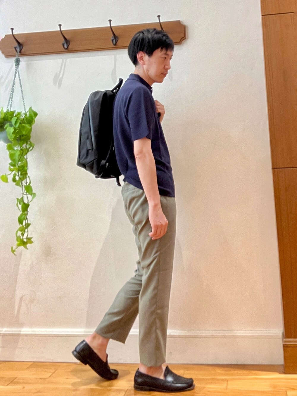 ブルー系のポロシャツ、ブラック系のバックパック/リュック、ブラック系のその他パンツを着用したメンズの春コーディネートの6枚目の写真