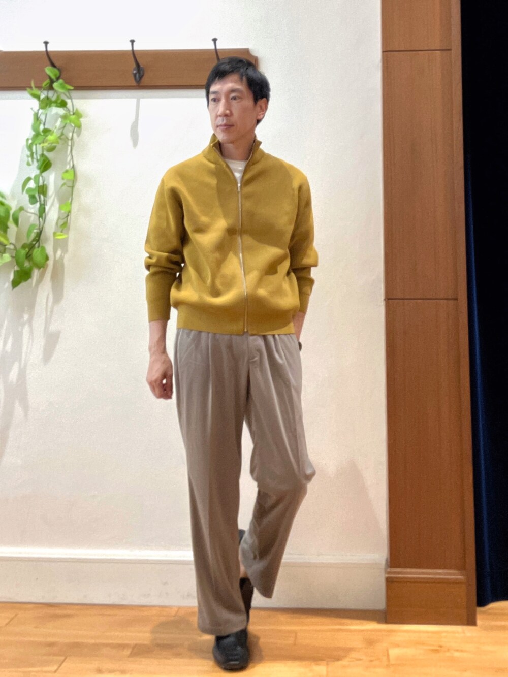 イエロー系のニット/セーター、ホワイト系のTシャツ/カットソー、ブラック系のショルダーバッグを着用したメンズの秋コーディネートの7枚目の写真