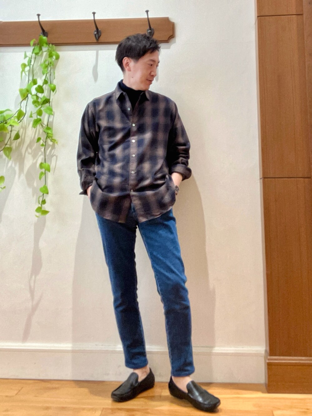 グリーン系のシャツ/ブラウス、ブルー系のニット/セーター、ブルー系のデニムパンツを着用したメンズの冬コーディネートの2枚目の写真