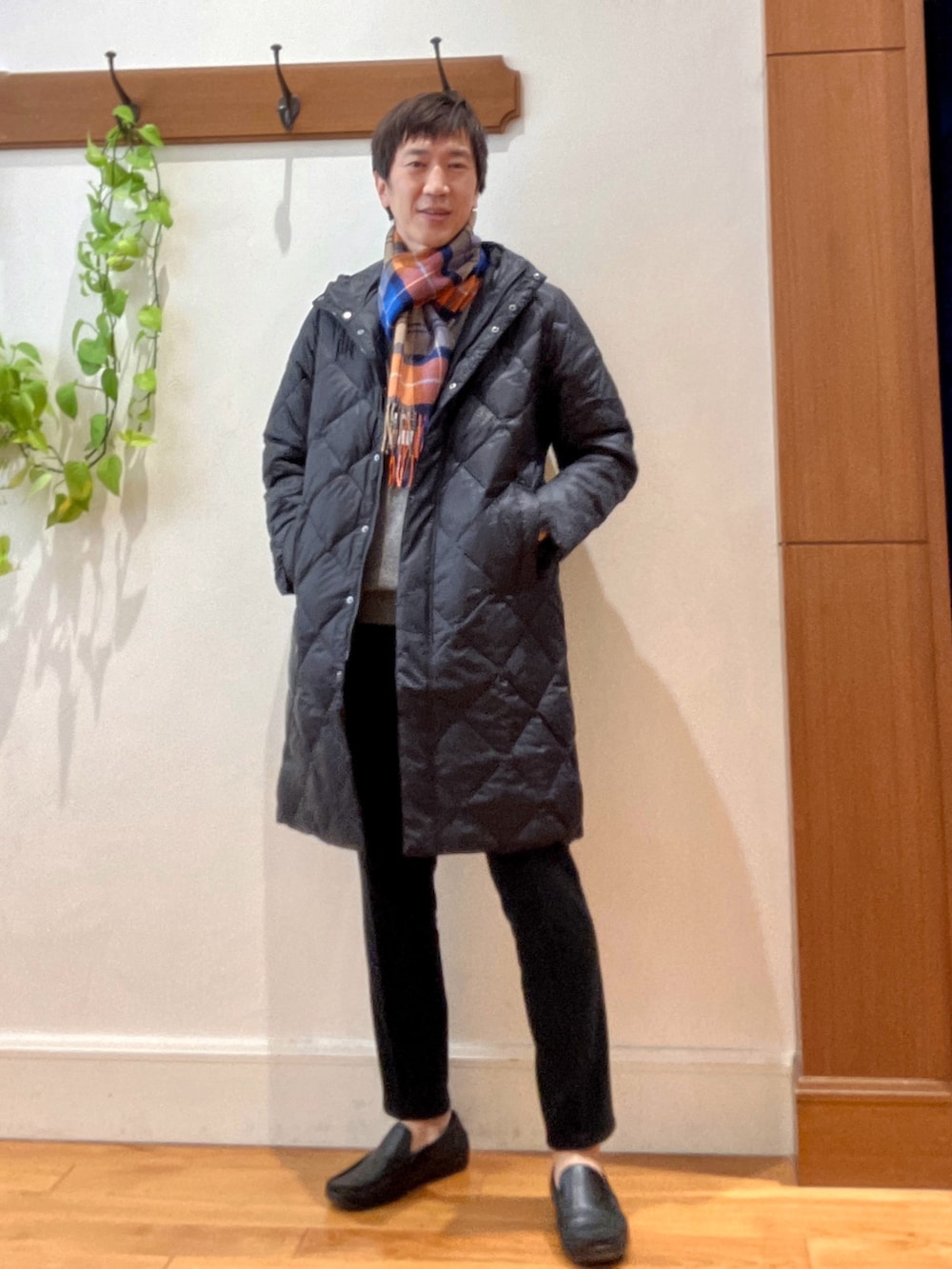 ブラック系のダウンジャケット/コート、グレー系のニット/セーター、ブラック系のその他パンツを着用したメンズの秋コーディネートの2枚目の写真