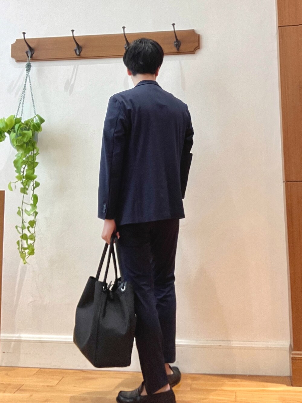 ブラック系のトートバッグ、ベージュ系のTシャツ/カットソー、ブルー系のテーラードジャケットを着用したメンズの春コーディネートの4枚目の写真