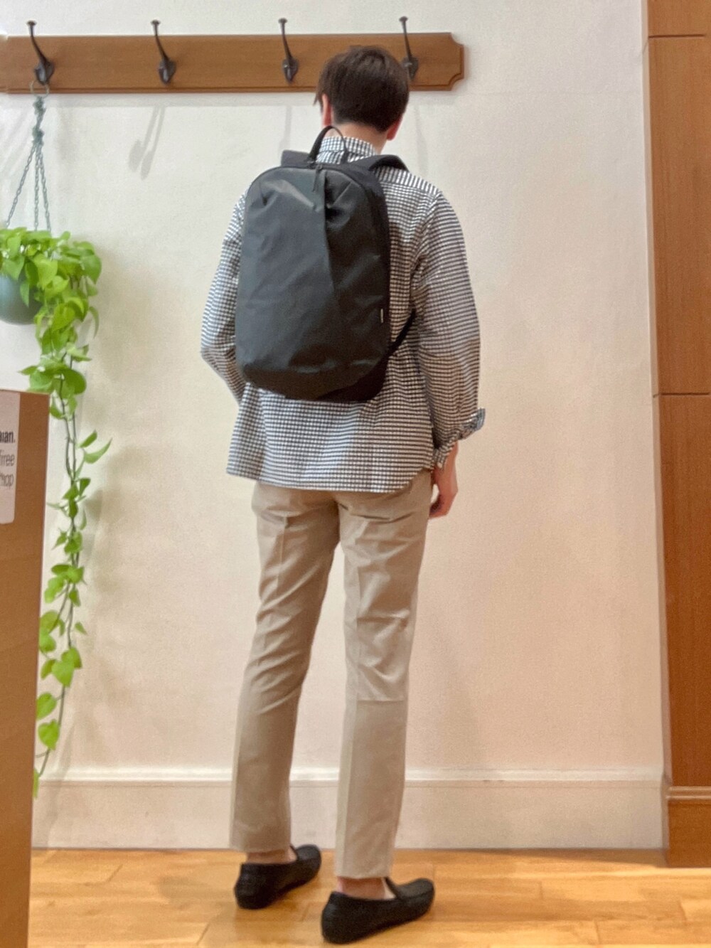 ブラック系のシャツ/ブラウス、グレー系のバックパック/リュック、ベージュ系のチノパンツを着用したメンズの春コーディネートの5枚目の写真