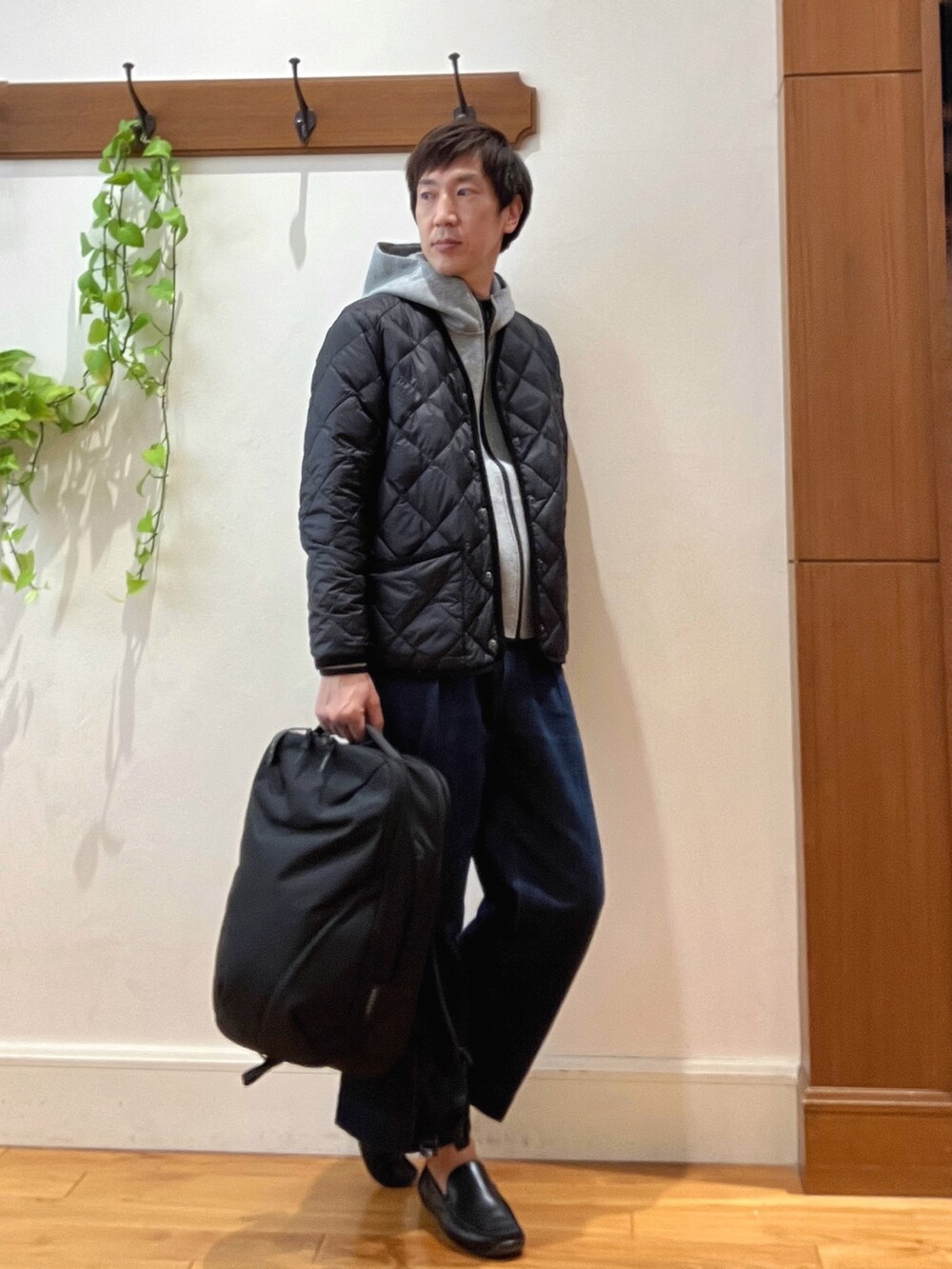 ブラック系のダウンジャケット/コート、グレー系のパーカー、ブラック系のバックパック/リュックを着用したメンズの秋コーディネートの8枚目の写真