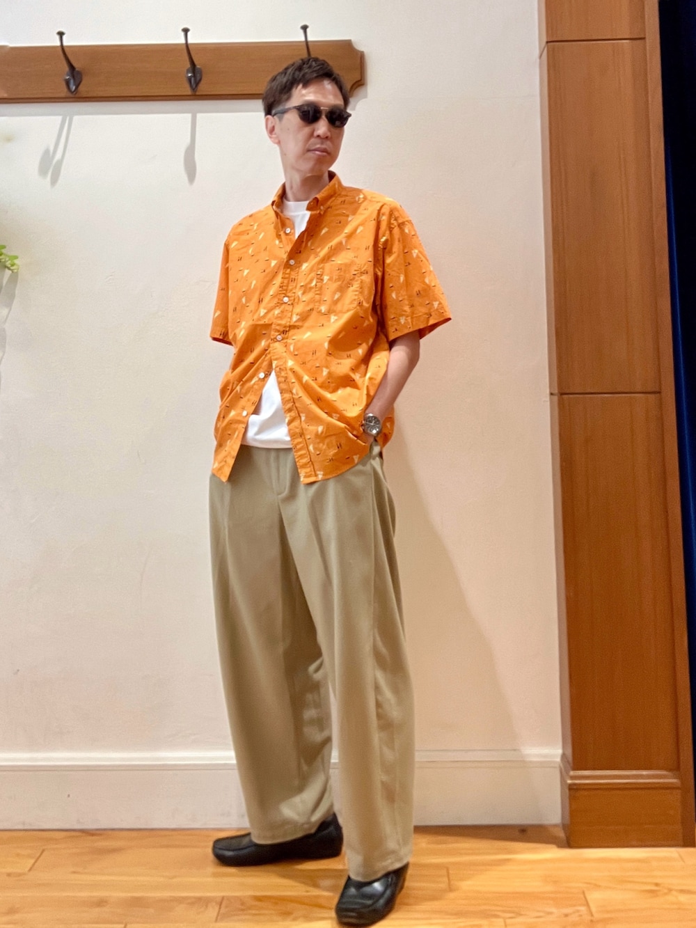 オレンジ系のシャツ/ブラウス、ホワイト系のTシャツ/カットソー、ブラウン系のサングラスを着用したメンズの夏コーディネートの3枚目の写真