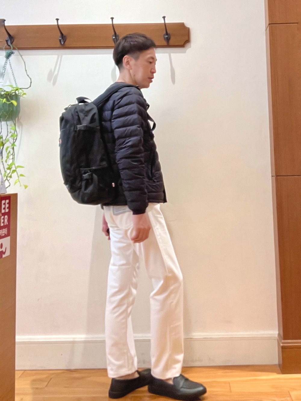 ブラック系のダウンジャケット/コート、パープル系のTシャツ/カットソー、ブラック系のショルダーバッグを着用したメンズの秋コーディネートの6枚目の写真