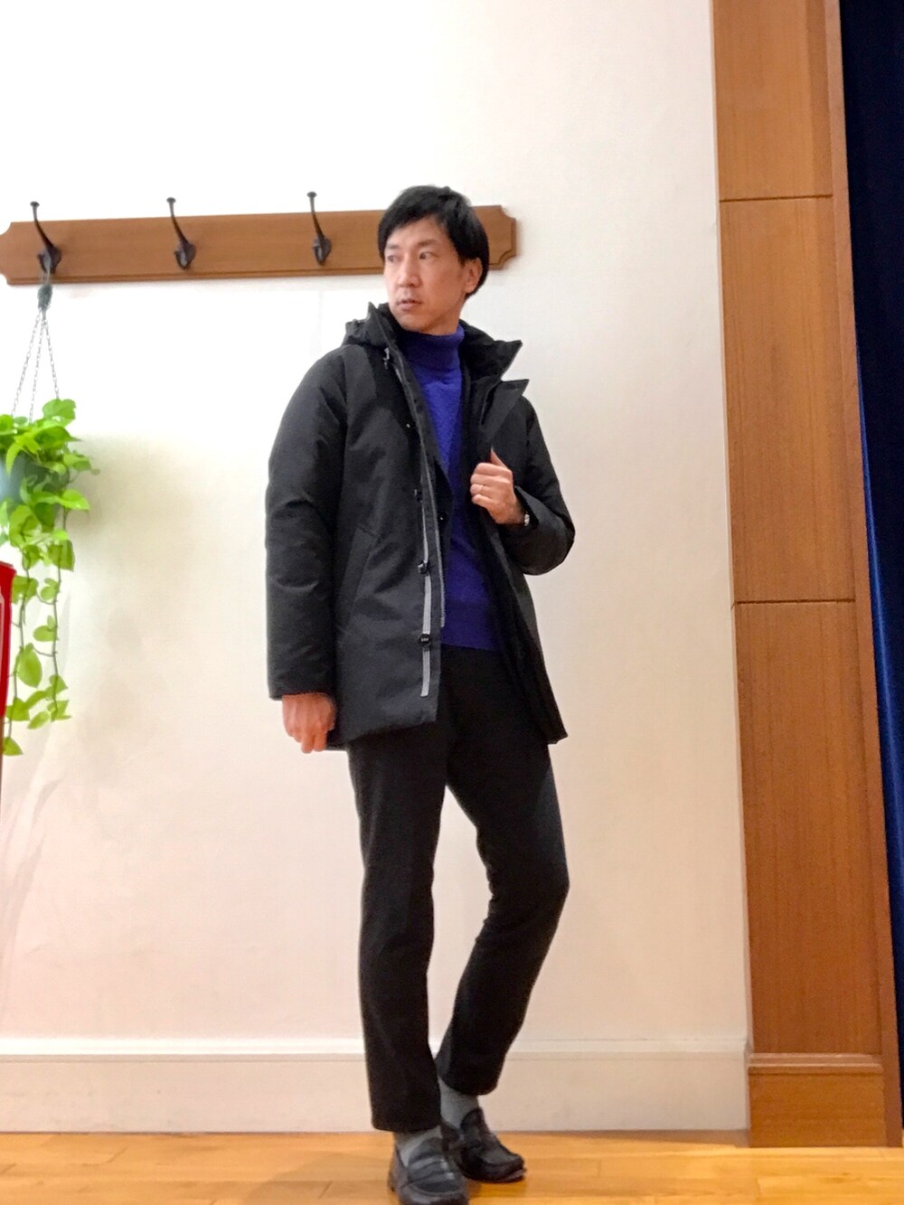 ブラック系のダウンジャケット/コート、ブルー系のニット/セーター、グレー系のその他パンツを着用したメンズの冬コーディネートの2枚目の写真