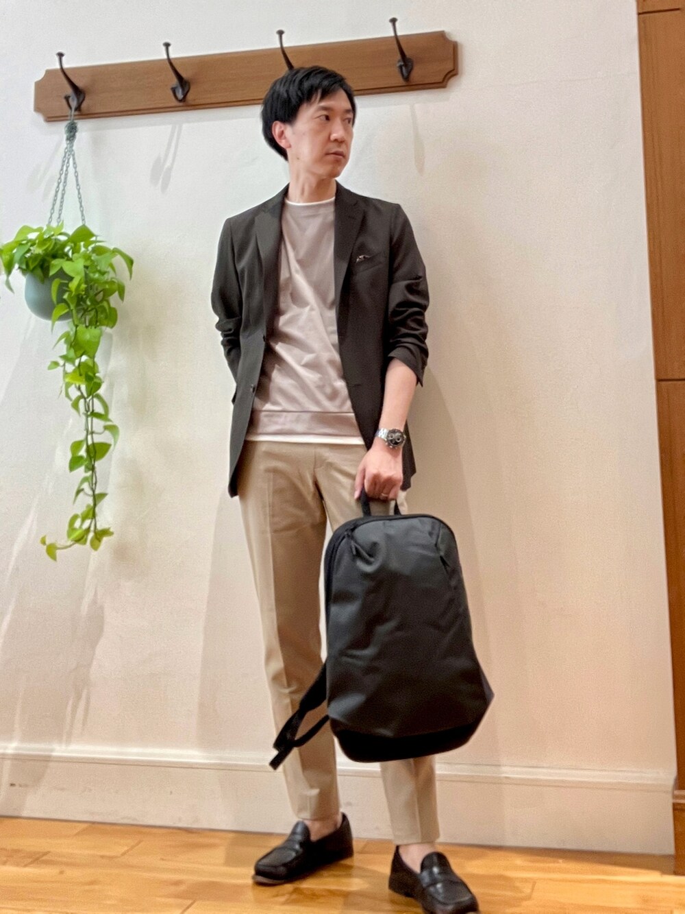 ブラウン系のテーラードジャケット、ベージュ系のTシャツ/カットソー、ブラック系のバックパック/リュックを着用したメンズの春コーディネートの2枚目の写真