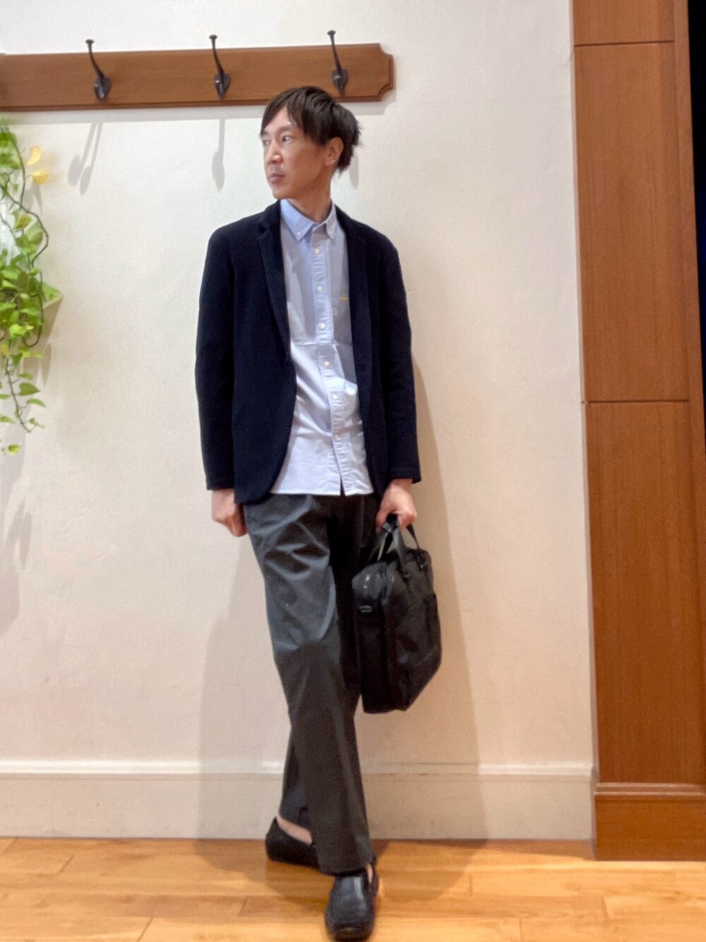 ブルー系のカーディガン/ボレロ、ブルー系のシャツ/ブラウス、ブラック系のビジネスバッグを着用したメンズの秋コーディネートの7枚目の写真