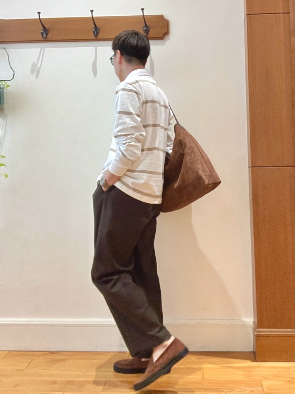 イエロー系のショルダーバッグ、ブラウン系のスニーカー、ホワイト系のTシャツ/カットソーを着用したメンズの秋コーディネートの5枚目の写真