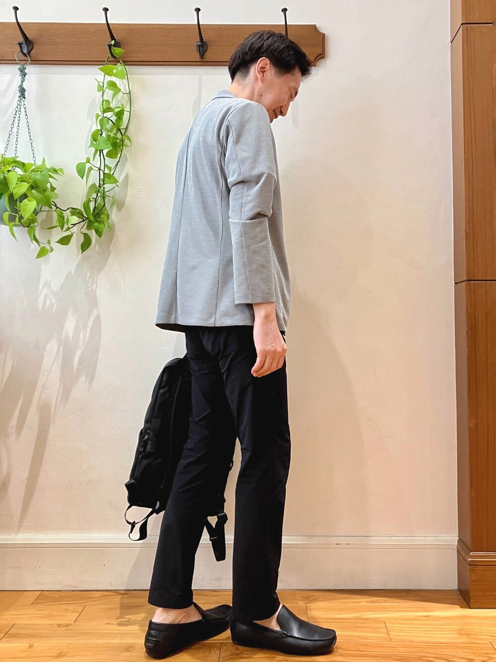 ブラック系のTシャツ/カットソー、グレー系のカーディガン/ボレロ、ブラック系のバックパック/リュックを着用したメンズの春コーディネートの6枚目の写真
