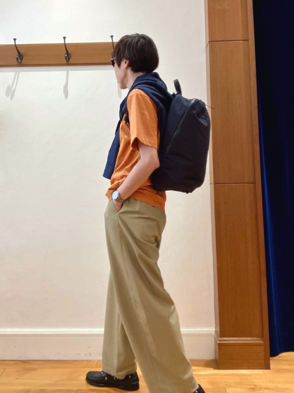 ブラック系のバックパック/リュック、ブルー系のシャツ/ブラウス、オレンジ系のTシャツ/カットソーを着用したメンズの春コーディネートの4枚目の写真