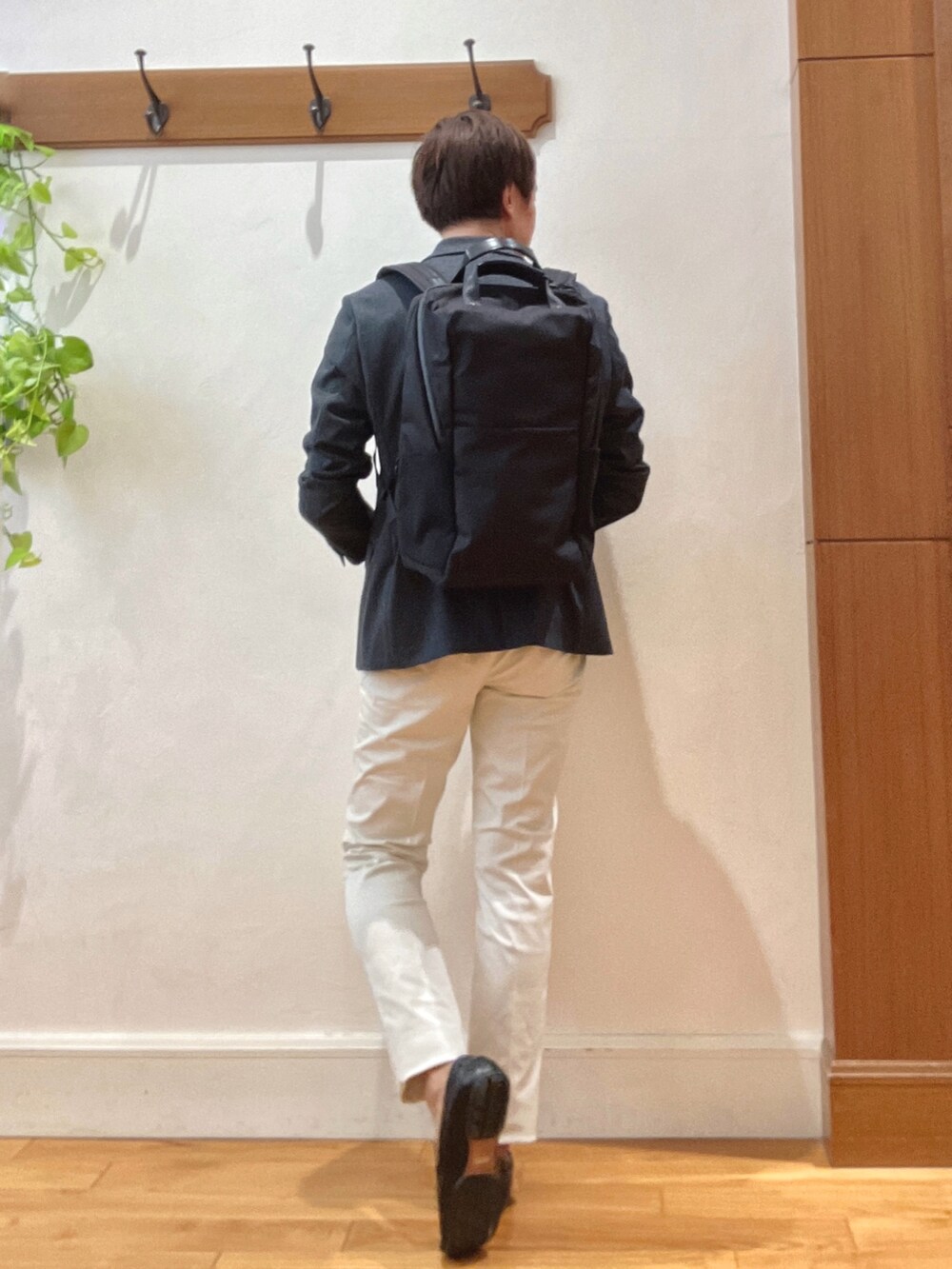 ホワイト系のチノパンツ、ブラック系のバックパック/リュック、ブルー系のテーラードジャケットを着用したメンズの秋コーディネートの5枚目の写真