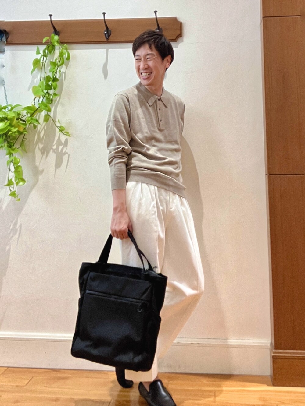 ホワイト系のデニムパンツ、ブラック系のトートバッグ、ベージュ系のニット/セーターを着用したメンズの冬コーディネートの8枚目の写真