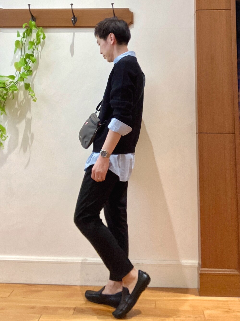 ブラック系のニット/セーター、グレー系のショルダーバッグ、ブルー系のシャツ/ブラウスを着用したメンズの春コーディネートの4枚目の写真